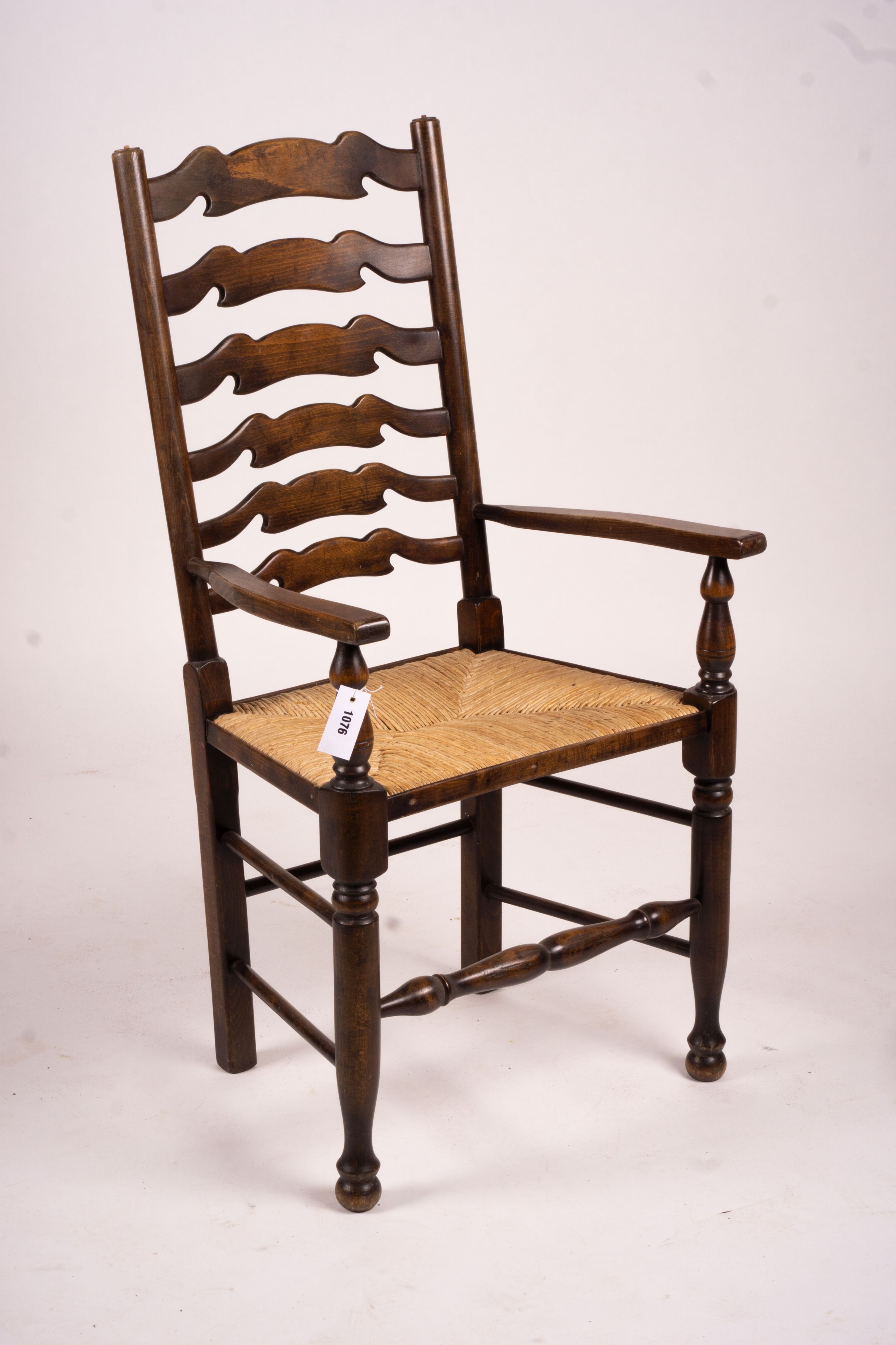 A set of ten 18th century style beech ladderback rush seat dining chairs, two with arms